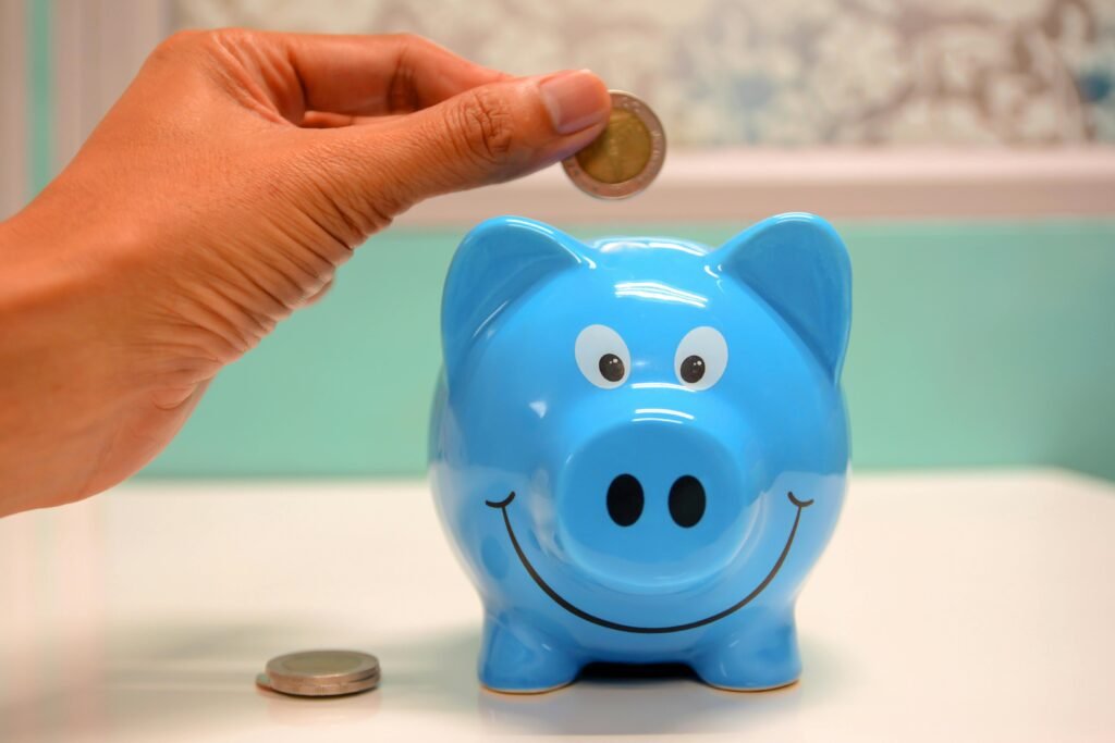 pexels-photo-1602726-1602726 Person Putting Coin in a Piggy Bank